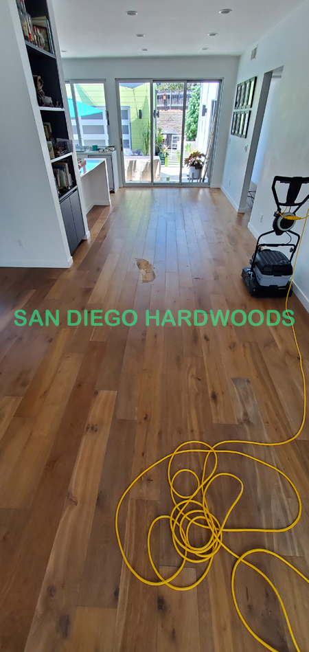Wire-brushed hardwood floor deep cleaned in San Diego home using a Bona PowerScrubber; dirt lifted from textured wood grain before protective recoating. Ideal alternative to steam cleaning or chemical floor services.